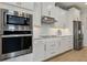 Modern kitchen featuring built-in appliances, white cabinetry, marble countertops, subway backsplash, and stainless steel finishes at 9844 Beach Port Dr, Winter Garden, FL 34787