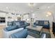 Bright living room with blue couches, open to the kitchen with white cabinetry and stainless steel appliances at 9844 Beach Port Dr, Winter Garden, FL 34787