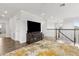 Upstairs bonus room with railing, modern light fixture, and media cabinet with large television at 9844 Beach Port Dr, Winter Garden, FL 34787