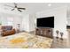 Living room with a large TV, comfortable seating, ceiling fan, and hardwood floors at 9844 Beach Port Dr, Winter Garden, FL 34787