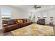 Spacious living room with a large leather sofa, stylish rug, and ceiling fan at 9844 Beach Port Dr, Winter Garden, FL 34787