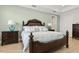 Comfortable main bedroom features a dark wood bed frame, coordinated lamps, and an abundance of natural light at 9844 Beach Port Dr, Winter Garden, FL 34787