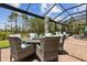 Screened-in patio with dining and lounge furniture under a sunny sky at 9844 Beach Port Dr, Winter Garden, FL 34787