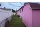Side yard featuring a pink home and shed with a white fence at 1038 26Th St, Orlando, FL 32805