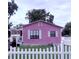 Quaint pink bungalow with white trim, a covered porch, and a charming picket fence at 1038 26Th St, Orlando, FL 32805