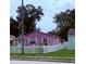 Charming pink home featuring a classic picket fence, lush lawn and mature trees at 1038 26Th St, Orlando, FL 32805