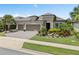 Charming home featuring a well-manicured lawn, mature landscaping, and a three-car garage at 1212 Zeek Ridge St, Clermont, FL 34715