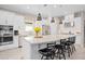 Bright, open kitchen featuring a large island with bar seating, stainless steel appliances, and modern pendant lighting at 1212 Zeek Ridge St, Clermont, FL 34715