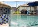 Relaxing backyard pool with cascading mosaic tile water feature, perfect for outdoor enjoyment at 1212 Zeek Ridge St, Clermont, FL 34715
