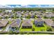 Areal view showcasing a residential neighborhood with lush green lawns and a serene lake in the distance at 12216 Prairie Plantation Way, Orlando, FL 32824