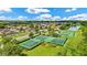 Aerial view of community tennis and basketball courts surrounded by homes and greenery at 12216 Prairie Plantation Way, Orlando, FL 32824