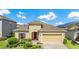 Charming single-story home with tan exterior, a two-car garage, and neatly manicured landscaping at 12216 Prairie Plantation Way, Orlando, FL 32824