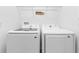 Laundry room featuring modern, front-loading washer and dryer with overhead shelving at 12216 Prairie Plantation Way, Orlando, FL 32824