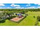 Colorful fenced playground with swings and slide in a grassy park area with mature trees and a gazebo at 12216 Prairie Plantation Way, Orlando, FL 32824