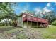 Back of home with a large deck, overlooking a sloping lawn at 1335 E 3Rd Ave, Mount Dora, FL 32757