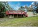 The backyard features a raised deck with red railings and a lush green lawn at 1335 E 3Rd Ave, Mount Dora, FL 32757