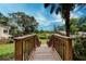 The wooden stairway looks out over the yard with lush greenery in the background at 1335 E 3Rd Ave, Mount Dora, FL 32757
