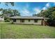 A home with green siding, green shutters and a stone chimney at 1335 E 3Rd Ave, Mount Dora, FL 32757