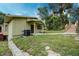Quaint single-story home with a covered entryway and lush greenery surrounding the property at 1335 E 3Rd Ave, Mount Dora, FL 32757