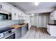 Well-appointed kitchen with white cabinets, stainless steel appliances, and wood flooring at 1335 E 3Rd Ave, Mount Dora, FL 32757