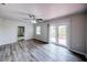 Bright living room with wood floors, ceiling fan, and sliding glass doors leading to an outdoor deck at 1335 E 3Rd Ave, Mount Dora, FL 32757