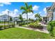 Landscaped backyard with green grass, walkway, garden and a covered patio with outdoor furniture at 14366 Walcott Ave, Orlando, FL 32827