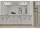 Modern bathroom with double sink vanity, quartz countertops, large mirror, walk-in shower, and wood-look tile flooring at 14366 Walcott Ave, Orlando, FL 32827