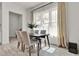 Sunlit dining area featuring a modern wooden table and chairs, with sheer curtains over a bright window at 14366 Walcott Ave, Orlando, FL 32827