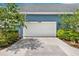 Garage door with blue facade and greenery on both sides at 14366 Walcott Ave, Orlando, FL 32827