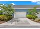 This lovely garage has a white door, blue facade with greenery and flowers surrounding it at 14366 Walcott Ave, Orlando, FL 32827