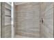 Walk-in shower featuring neutral tile, glass door, shower niche, and sleek fixtures at 14366 Walcott Ave, Orlando, FL 32827