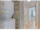 Convenient laundry room with stacked washer/dryer and shelves adjacent to the main hallway at 150 Wax Myrtle Woods Ct # 3D, Deltona, FL 32725