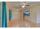 Open-concept living room with light hardwood floors, ceiling fan, and access to a kitchen area at 150 Wax Myrtle Woods Ct # 3D, Deltona, FL 32725