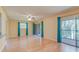 Bright, open living room featuring hardwood floors, ceiling fan, neutral paint, and sliding glass doors at 150 Wax Myrtle Woods Ct # 3D, Deltona, FL 32725