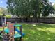 Backyard with green grass, large trees, and a playset at 1501 Delaware Ave, St Cloud, FL 34769