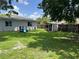 Spacious backyard featuring lush grass, a wooden fence, slide and a shed at 1501 Delaware Ave, St Cloud, FL 34769
