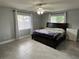Bedroom with gray walls, ceiling fan, tile floors, and a large bed with a dark wood frame at 1501 Delaware Ave, St Cloud, FL 34769