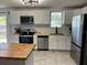 Modern kitchen with white cabinetry, stainless steel appliances and butcher block countertops at 1501 Delaware Ave, St Cloud, FL 34769