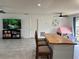 Open-concept living space featuring an island with seating, a large TV, and tiled floors at 1501 Delaware Ave, St Cloud, FL 34769