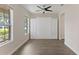 Bedroom with grey wood floors, built-in cabinets and drawers, a ceiling fan, and two windows at 15229 Evergreen Oak Loop, Winter Garden, FL 34787