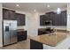 Well-equipped kitchen with stainless steel appliances, dark cabinetry, and granite countertops at 15229 Evergreen Oak Loop, Winter Garden, FL 34787