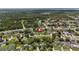 An aerial view of the home and neighborhood with mature trees and lake access a short drive away at 1591 Pendleton St, Deltona, FL 32725