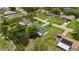 An aerial view shows the neighborhood and the home's lot with mature trees and a screened in patio at 1591 Pendleton St, Deltona, FL 32725