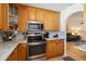 Charming kitchen featuring granite counters, stainless appliances, and wood cabinets at 1591 Pendleton St, Deltona, FL 32725