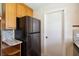Kitchen with black refrigerator, granite countertops, and wooden cabinets at 1591 Pendleton St, Deltona, FL 32725