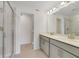 Modern bathroom with double vanity, quartz countertops, and a glass-enclosed shower at 1689 Greenleaf Woods Cv, Oviedo, FL 32765