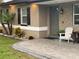 Home exterior featuring a stone facade, well-manicured landscaping, gray door, and brick paver walkway at 170 N Fairfax Ave, Winter Springs, FL 32708