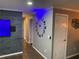 Hallway with a wall-mounted television and decorative elements; lighting and a series of doors at 170 N Fairfax Ave, Winter Springs, FL 32708