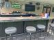 This outdoor bar features a tile countertop, bar stools, built-in grill, fridge, lights and fan, ready for entertainment at 170 N Fairfax Ave, Winter Springs, FL 32708