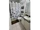 Clean bathroom featuring a shower with blue floral curtain, toilet, and vanity with gray countertop at 1815 Townhall Ln # 1815, Orlando, FL 32807